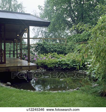 Circular pond in country garden with oriental building View Large Photo Image Stock Photograph - Circular pond in country garden with oriental building. Fotosearch
