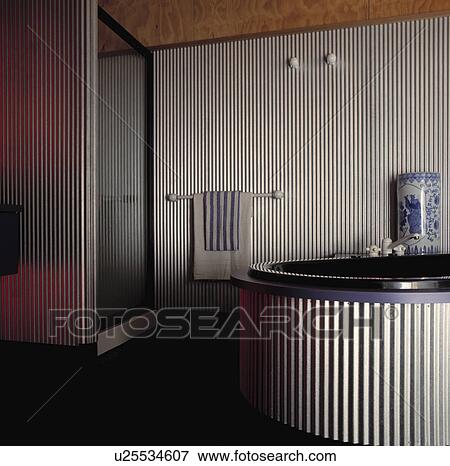 Circular spa tub with corrugated metal surround in modern bathroom with corrugated metal walls and shower cabinet View Large Photo Image Stock Photo - Circular spa tub with corrugated metal surround in modern bathroom with corrugated metal walls and shower cabinet. Fotosearch