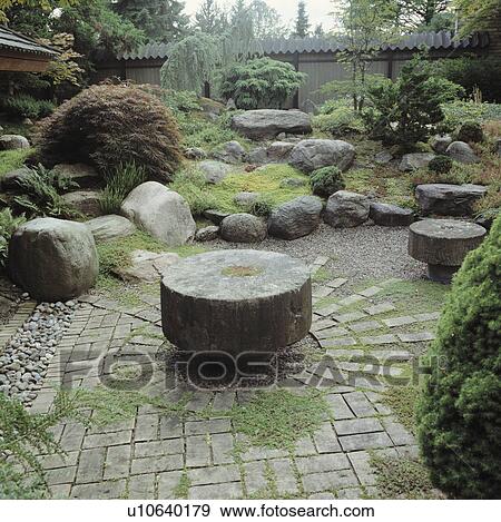 Stock Photo - Circular stone table in paving in oriental-style country garden. Fotosearch