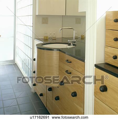 Circular undermounted basin built into beech units in streamlined modern bathroom View Large Photo Image Stock Image - Circular undermounted basin built into beech units in streamlined modern bathroom. Fotosearch