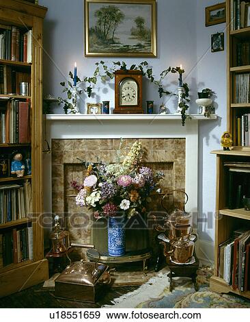 Clock and lighted candles on mantelpiece above fireplace with fresh flower arrangement View Large Photo Image Stock Photo - Clock and lighted candles on mantelpiece above fireplace with fresh flower arrangement. Fotosearch