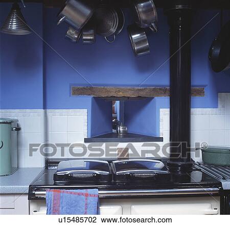Stock Image - Close-up of alcove above Rayburn in blue cottage kitchen. Fotosearch