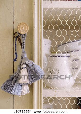 Close-up of blue and cream tassels on cream cupboard with wirework door View Large Photo Image Picture - Close-up of blue and cream tassels on cream cupboard with wirework door. Fotosearch