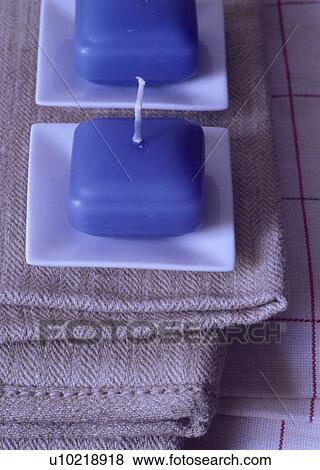 Stock Photo - Close-up of blue candles on white ceramic dishes. Fotosearch