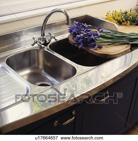 Stock Photo - Close-up of blue irises on double stainless steel sink. Fotosearch