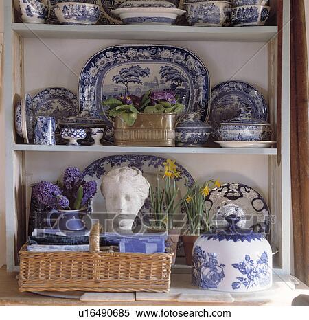 Stock Photography - Close-up of blue+white antique china on white shelves above marble head and basket. Fotosearch