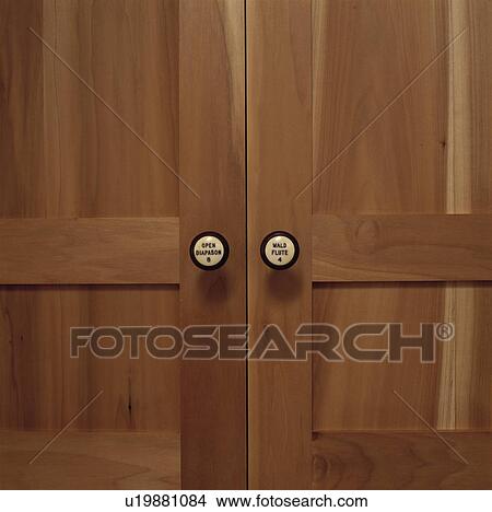 Picture - close-up of ceramic handles on Shaker style wooden doors. Fotosearch