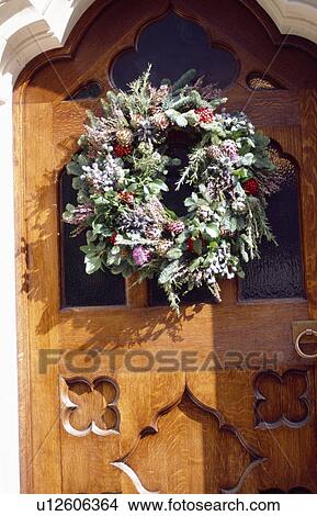 Picture - Close-up of Christmas wreath on traditional wooden front door . Fotosearch