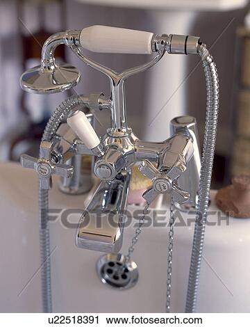 Stock Image - Close-up of chrome bath taps and showerhead . Fotosearch