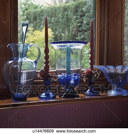 Stock Photo - Close-up of collection of blue glass jugs and bowls on windowsill. Fotosearch