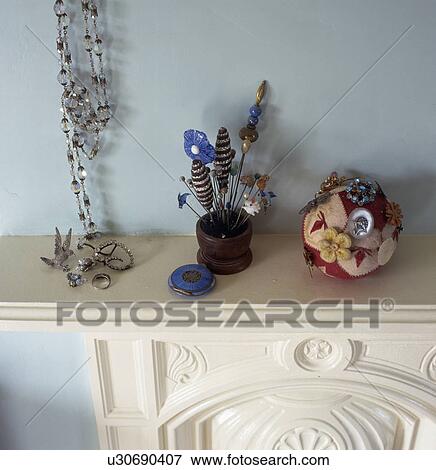 Close-up of collection of hatpins and broches on mantelpiece with string of glass beads View Large Photo Image Stock Photo - Close-up of collection of hatpins and broches on mantelpiece with string of glass beads. Fotosearch