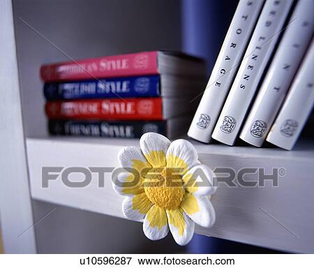Close up of contemporary painted plaster-of-paris daisy decoration attached to front of white shelf View Large Photo Image Stock Photo - Close up of contemporary painted plaster-of-paris daisy decoration attached to front of white shelf . Fotosearch