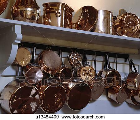 Close-up of copper pans and jugs on white shelf View Large Photo Image Stock Photo - Close-up of copper pans and jugs on white shelf. Fotosearch