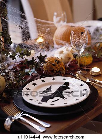 Picture - Close-up of cutlery and white plate decorated with Halloween motif . Fotosearch