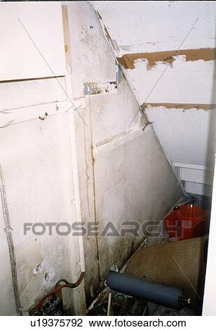 Stock Image - Close-up of dilapidated understairs wall showing damp. Fotosearch