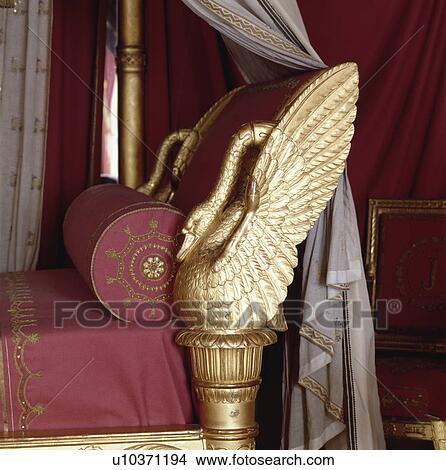 Picture - Close-up of gilt swan bedheads on rococo bed with red and gold linen. Fotosearch
