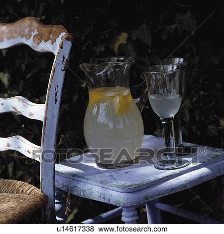Stock Photo - Close-up of glass jug of lemonade with stemmed glasses. Fotosearch
