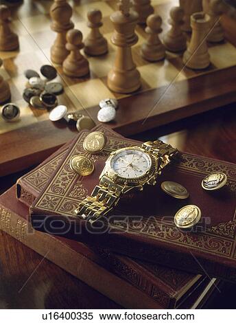 Stock Photography - Close-up of gold antique watch and brass buttons on books. Fotosearch