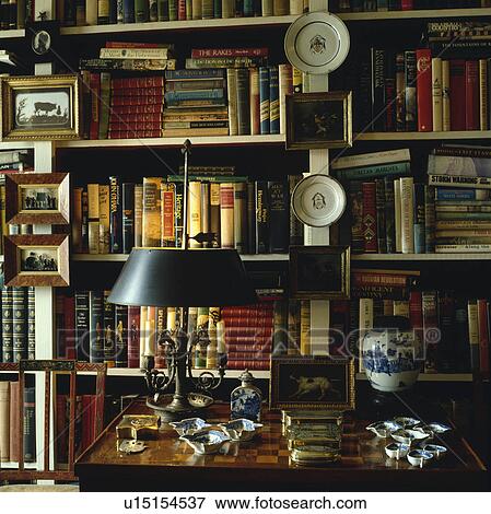 Close-up of lamp on table in front of bookshelves View Large Photo Image Stock Photo - Close-up of lamp on table in front of bookshelves. Fotosearch
