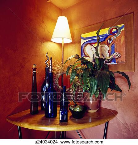 Close-up of lighted lamp and blue glass bottles on table View Large Photo Image Picture - Close-up of lighted lamp and blue glass bottles on table. Fotosearch