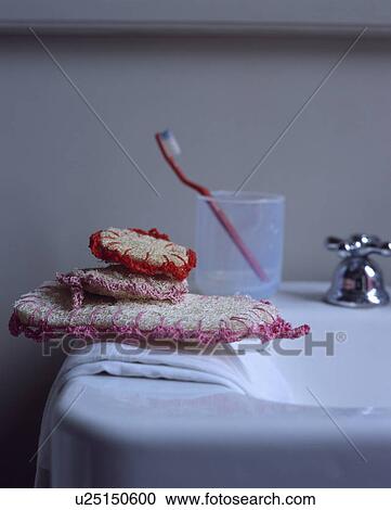 Close-up of loofahs and toothbrush in glass on edge of bath View Large Photo Image Stock Image - Close-up of loofahs and toothbrush in glass on edge of bath. Fotosearch