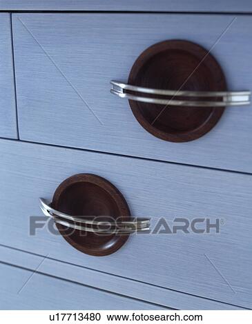 Stock Image - Close-up of metal handles on white kitchen drawers. Fotosearch