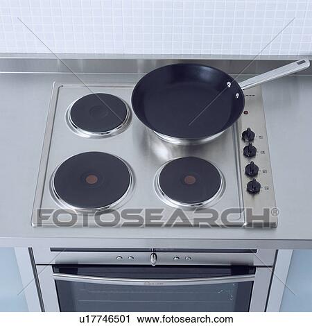 Close-up of nonstick pan on stainless steel electric hob View Large Photo Image Stock Image - Close-up of nonstick pan on stainless steel electric hob . Fotosearch
