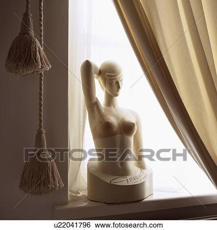 Stock Photograph - Close-up of old Gossard advertising bust against cream curtain. Fotosearch