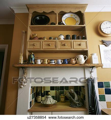 Picture - Close-up of pine shelf unit with drawers above kitchen fireplace. Fotosearch