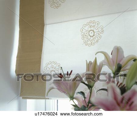 Picture - Close-up of pink lilies in front of cream Roman blind with neutral edging. Fotosearch