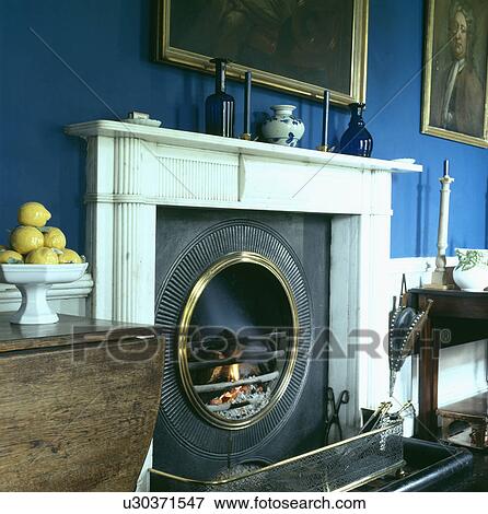 Close-up of rble mantelpiece with circular fireplace in blue living room View Large Photo Image Stock Photo - Close-up of rble mantelpiece with circular fireplace in blue living room. Fotosearch