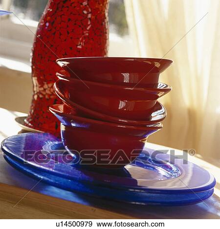 Stock Photo - Close up of red bowls on blue plates. Fotosearch