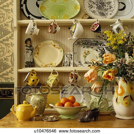 Close-up of shelves with vintage cups and plates on hooks above yellow teapot and fresh flowers in jug View Large Photo Image Stock Photograph - Close-up of shelves with vintage cups and plates on hooks above yellow teapot and fresh flowers in jug. Fotosearch