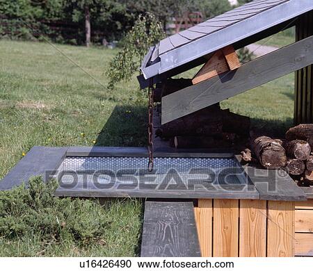 Stock Image - Close-up of small pool below wooden roof. Fotosearch