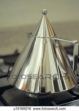 Stock Photograph - Close-up of stainless steel Conico kettle designed by Aldo Rossi for Alessi. Fotosearch