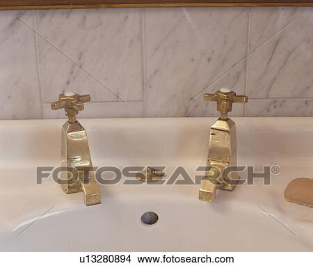 Close-up of white bathroom basin with brass taps View Large Photo Image Picture - Close-up of white bathroom basin with brass taps. Fotosearch