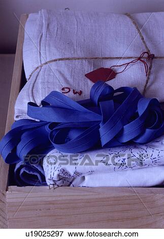 Close-up of white linen sheets and blue ribbon in wooden tray View Large Photo Image Stock Photo - Close-up of white linen sheets and blue ribbon in wooden tray. Fotosearch