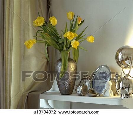 Close-up of yellow tulips in metallic vase and silver clocks on shelf View Large Photo Image Stock Image - Close-up of yellow tulips in metallic vase and silver clocks on shelf. Fotosearch