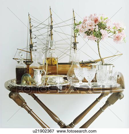 Stock Photo - Collection of antique glasses and decanters with model sailing ship on antique table. Fotosearch