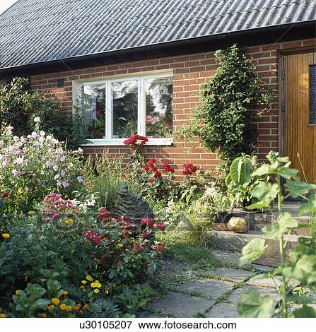 Stock Photo - Colourful flowering plants in garden of country cottage in summer . Fotosearch
