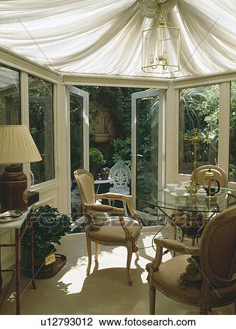 conservatory dining room with cream ceiling blinds and French doors open to patio garden View Large Photo Image Stock Image - conservatory dining room with cream ceiling blinds and French doors open to patio garden. Fotosearch
