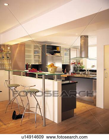 Contemporary wooden floored kitchen with glass breakfast bar and stainless stools. View Large Photo Image Stock Photo - Contemporary wooden floored kitchen with glass breakfast bar and stainless stools.. Fotosearch