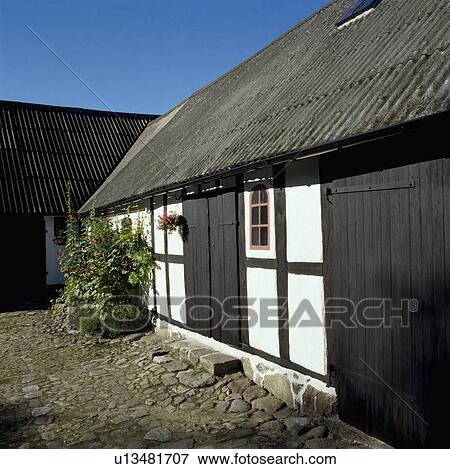 Corrugated roof on traditional black+white single-storey country cottage View Large Photo Image Stock Photo - Corrugated roof on traditional black+white single-storey country cottage. Fotosearch