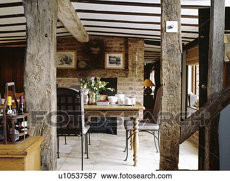 Stock Photo - Cottage dining room with plaster removed to reveal vertical wall beams. Fotosearch