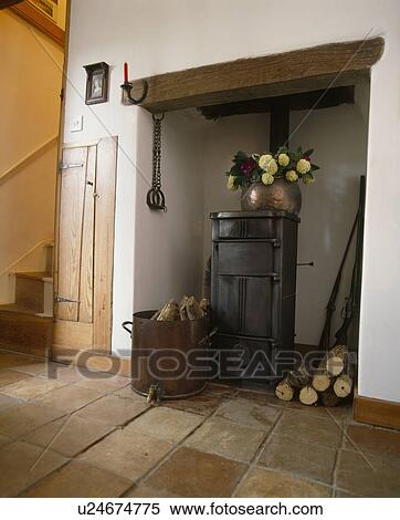 Cottage Hall With Logs In Old Copper Beside Cast Iron Stove In