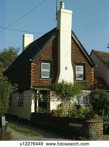 Stock Photo - Cottage with tall white chimney and pantiles on the walls. Fotosearch