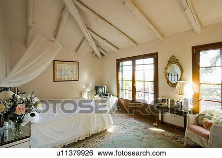 Stock Photograph - Country bedroom in Spain with beamed ceiling. Fotosearch