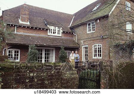 Couple outside traditional brick house View Large Photo Image Stock Image - Couple outside traditional brick house. Fotosearch