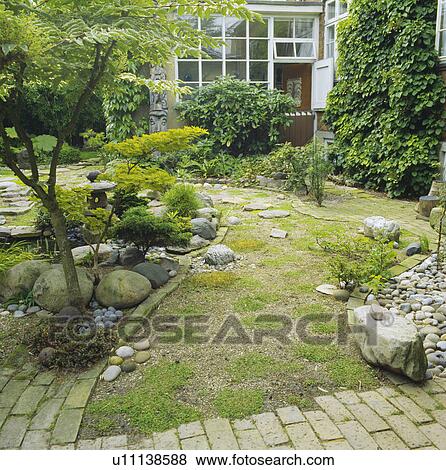 Stock Photo - Courtyard with brick paving and mossy gravel -oriental borders with boulders, sumach and golden japanese maple. Fotosearch
