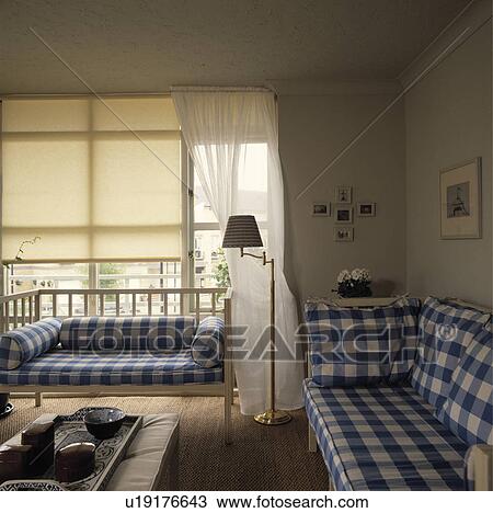 Cream blinds in living room with blue+white checked sofas View Large Photo Image Stock Image - Cream blinds in living room with blue+white checked sofas. Fotosearch